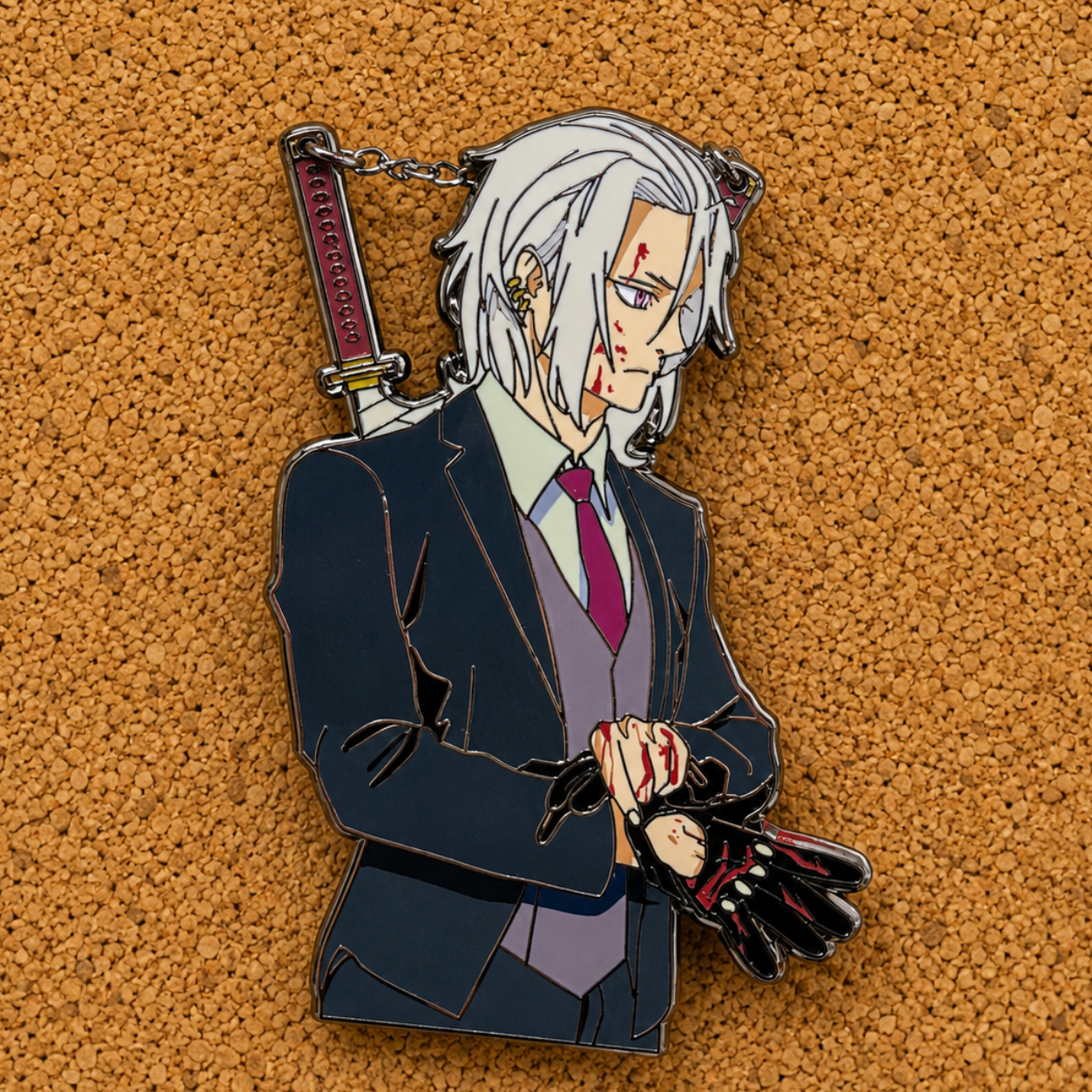 Tengen Uzui fan inspired hard enamel pin from Demon Slayer with chain detail, screen print accents, black nickel plating, and limited edition collector design on cork board background.
